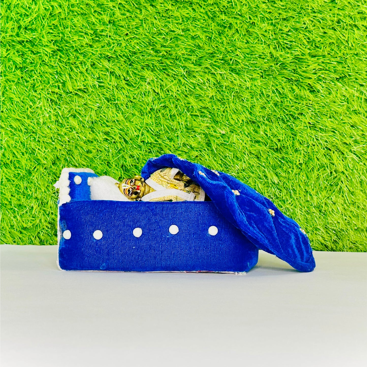 Laddu gopal ji sleeping beside a Blue Shaneel Pearl Work Wooden Laddu Gopal Bed with Blanket & Pillow.