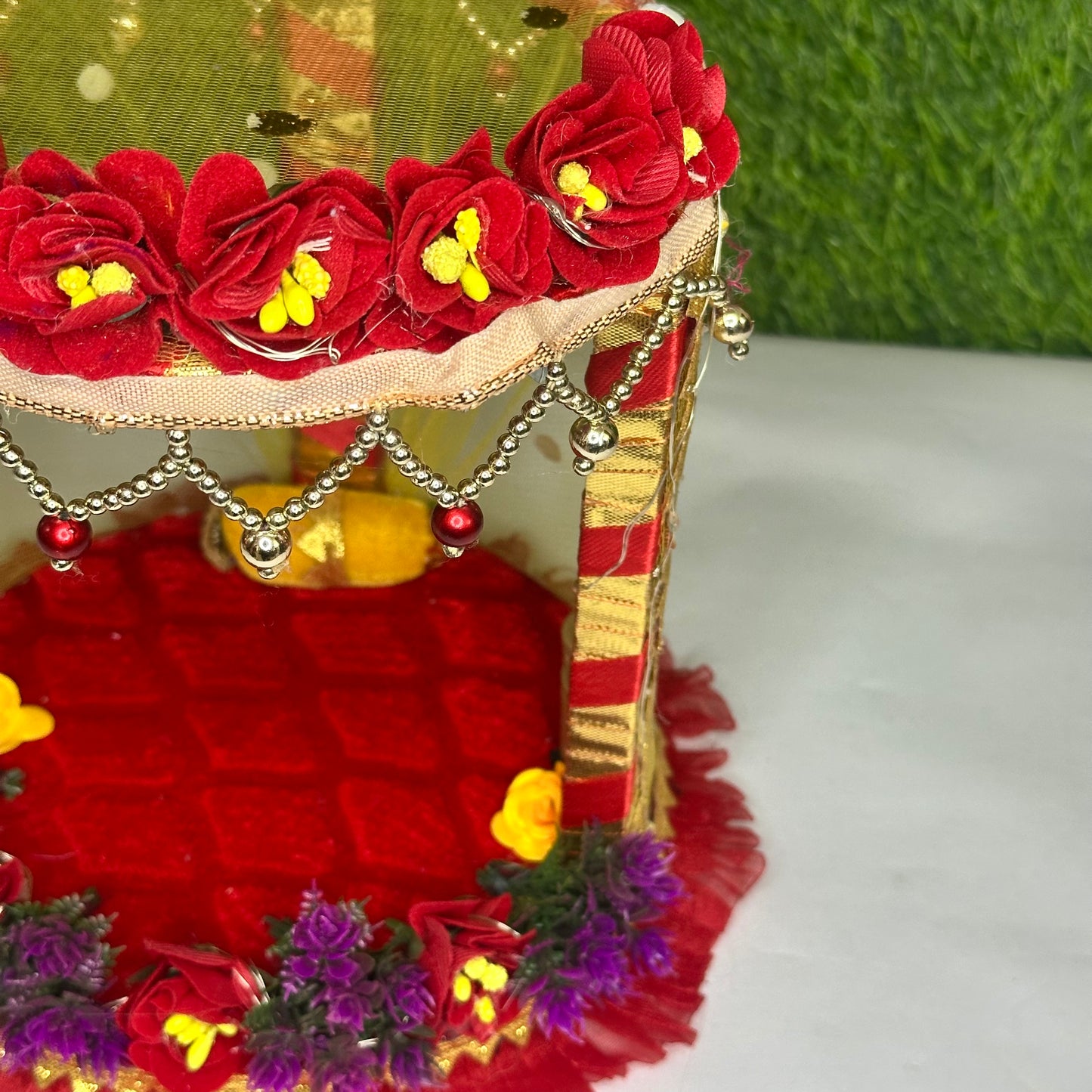 Right close up view of a decorative Red Floral Laddu Gopal Singhasan Bed with Pearl Hangings & LED Lights.