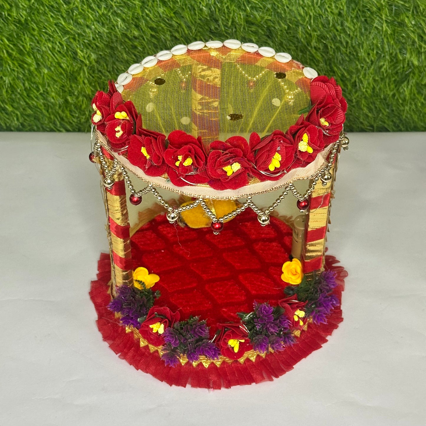 Top view of a decorative Red Floral Laddu Gopal Singhasan Bed with Pearl Hangings & LED Lights.