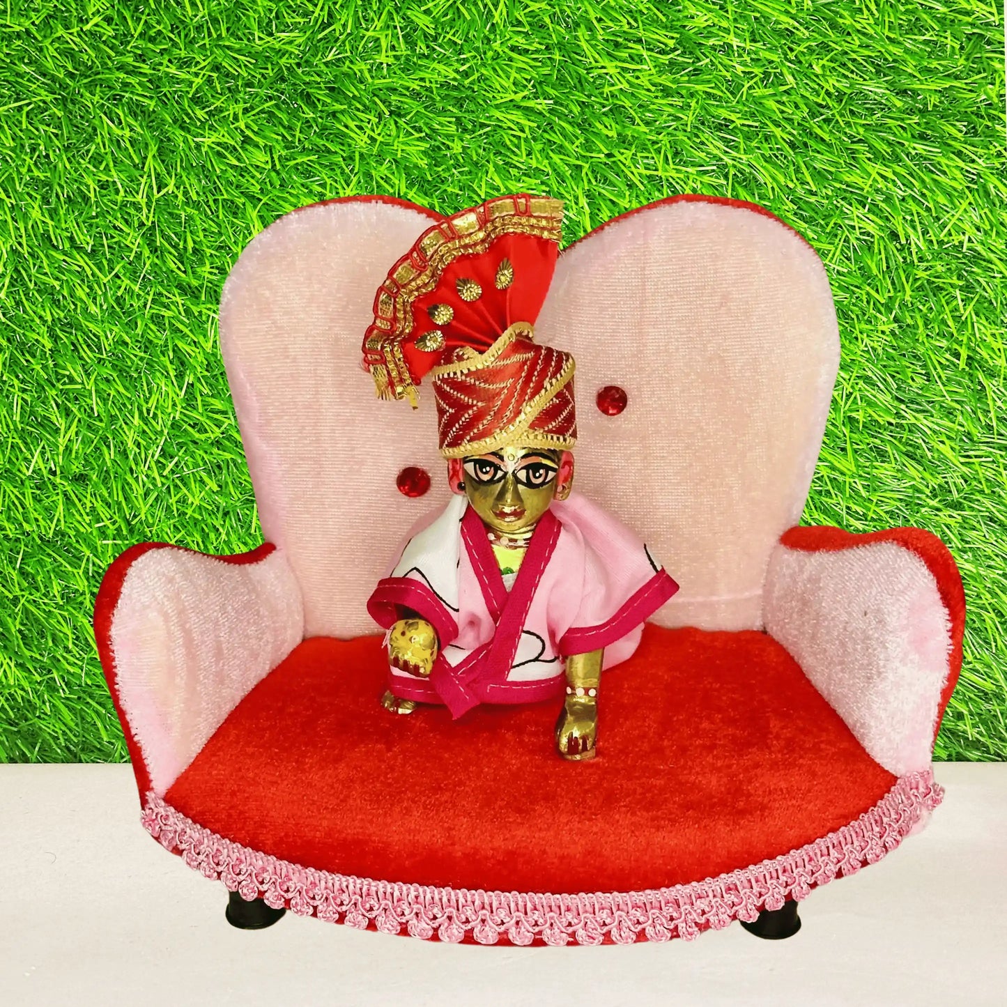 Kanha ji sitting on a Designer Pink & Red Velvet Laddu Gopal Sofa, a Comfortable Decorative Singhasan.