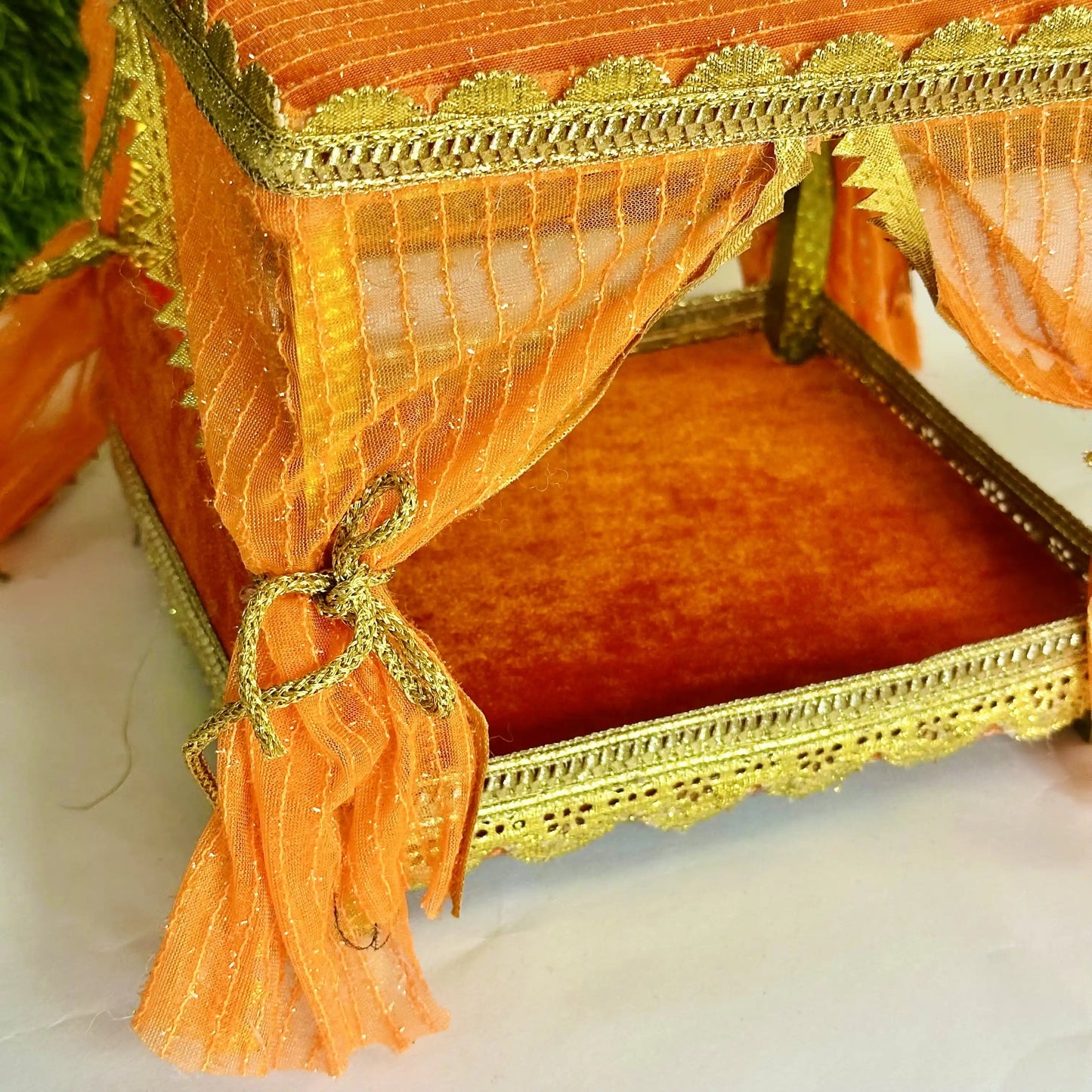 Close inside view of an Elegant Orange Decorative Laddu Gopal Singhasan with Designer Jhula with Curtains.