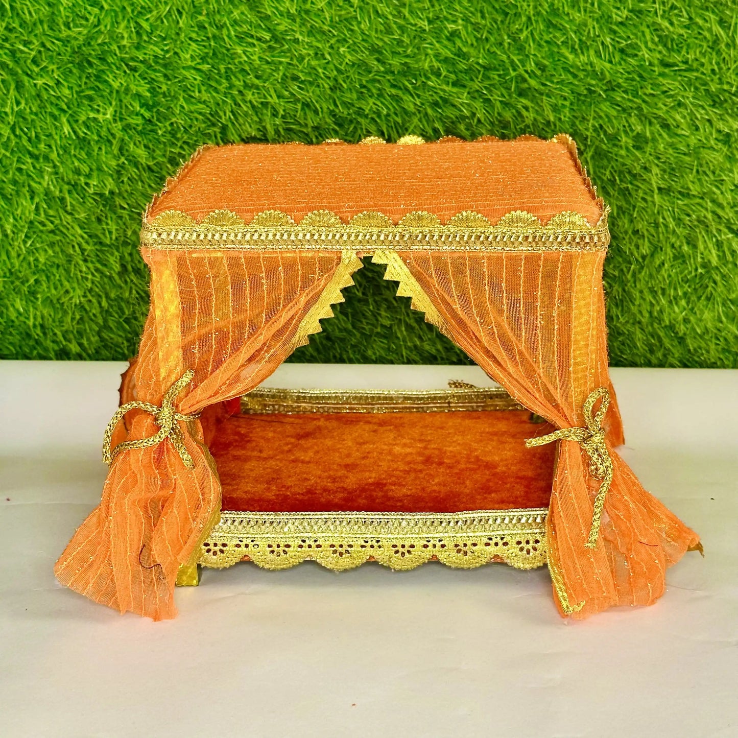 Front view of an Elegant Orange Decorative Laddu Gopal Singhasan with Designer Jhula with Curtains.