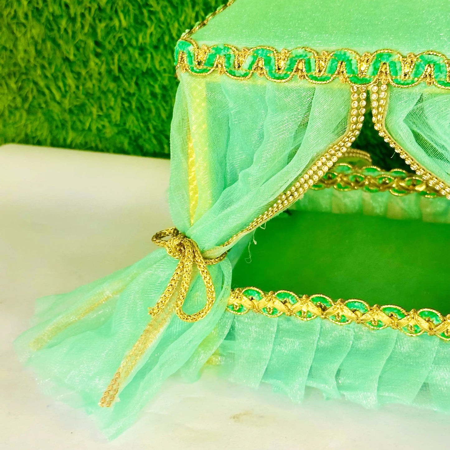 Close view of a Elegant Sea Green Laddu Gopal Jhula Singhasan with Golden Lace Border.