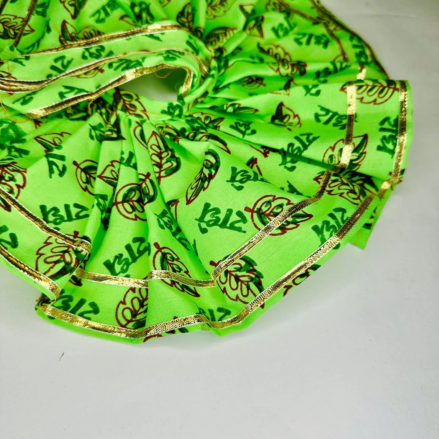 Close up view of a Bright Green Radhe Radhe Printed Laddu Gopal ji dress poshak with Golden Lace with Matching Pagdi.