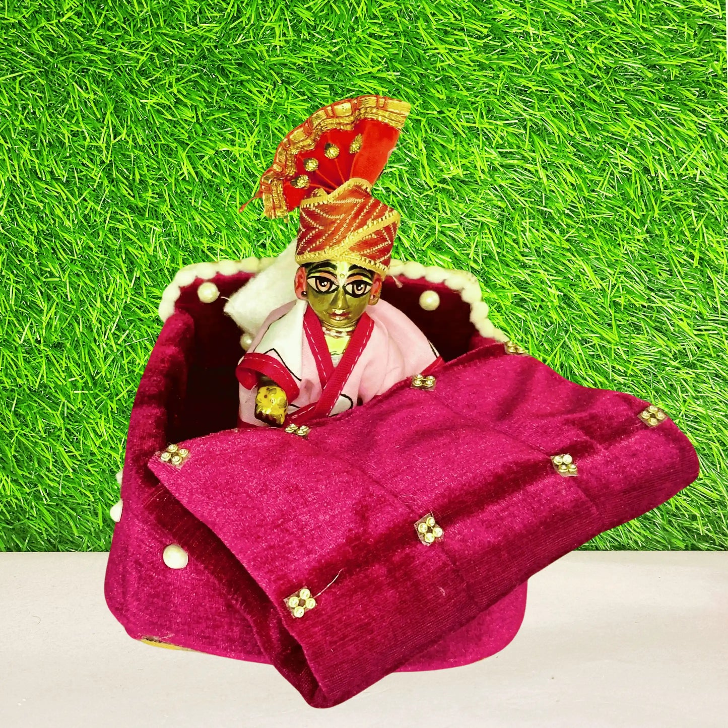 Laddu Gopal ji sitting in a Magenta Velvet Laddu Gopal Bedding Set with Pearl Border & Stone Work Blanket.