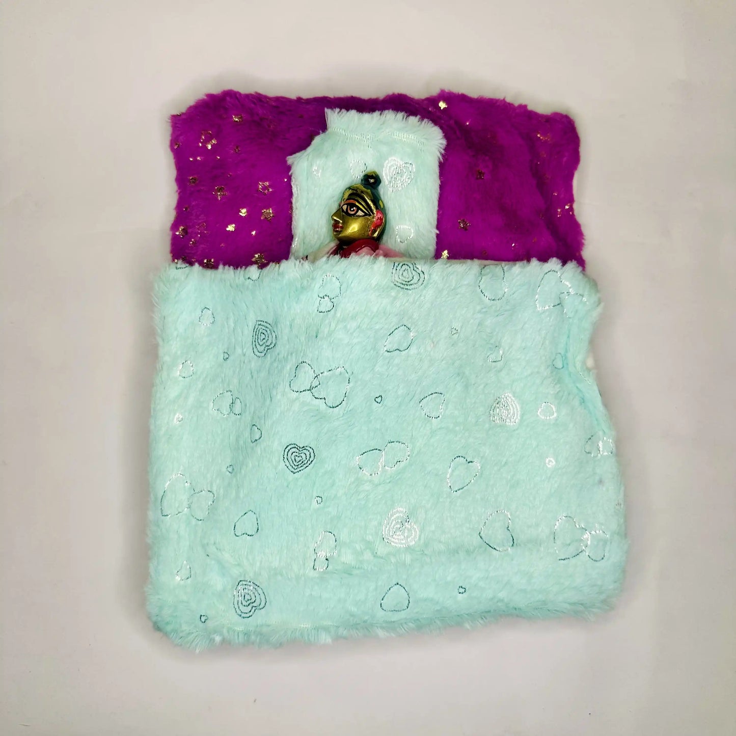 Top view of Laddu Gopal ji in a Mint Green & Purple Furry Laddu Gopal Bedding Set with Heart Print Blanket and Star Base