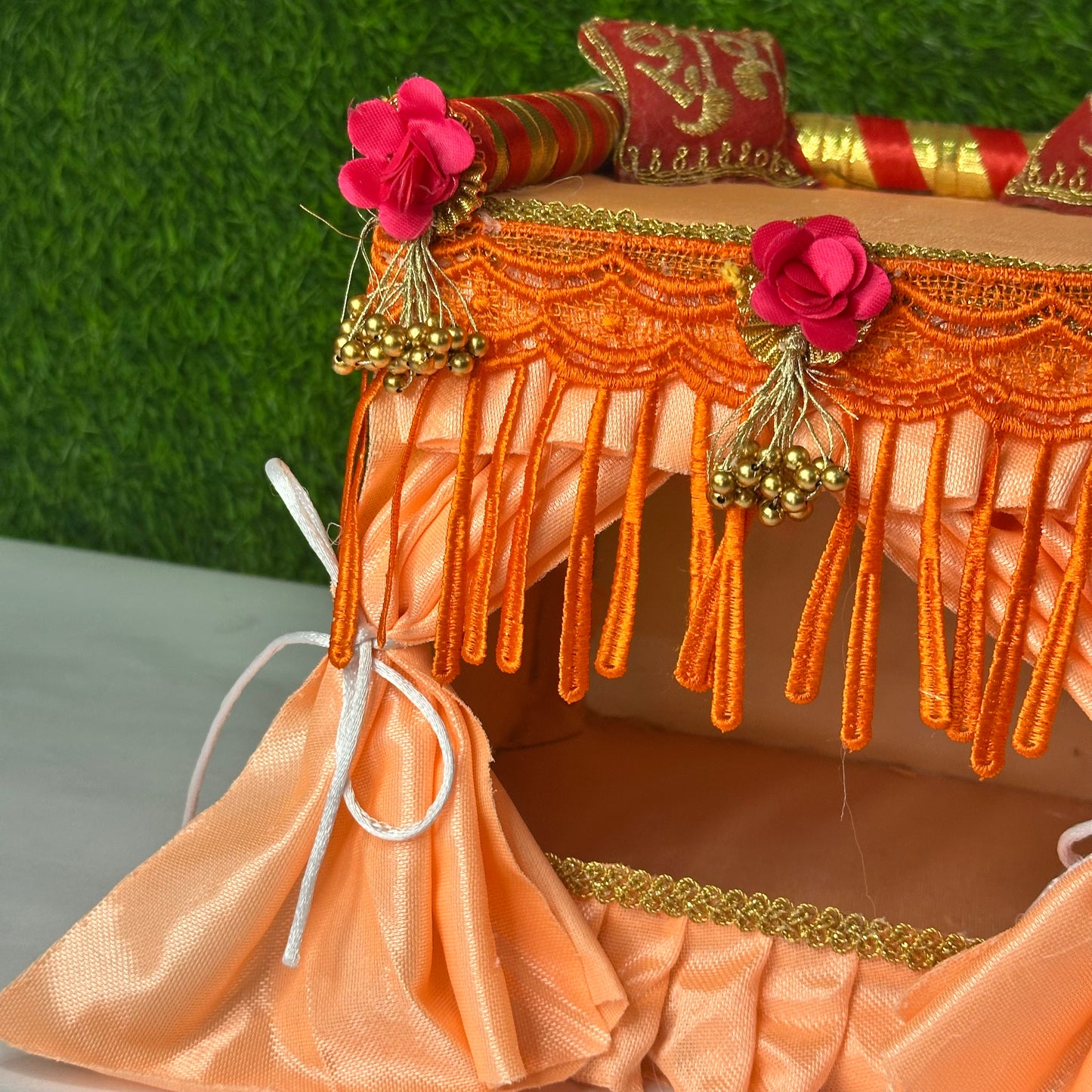 Close up look of peach color laddu gopal ji singhasan and bed with complete bedding.