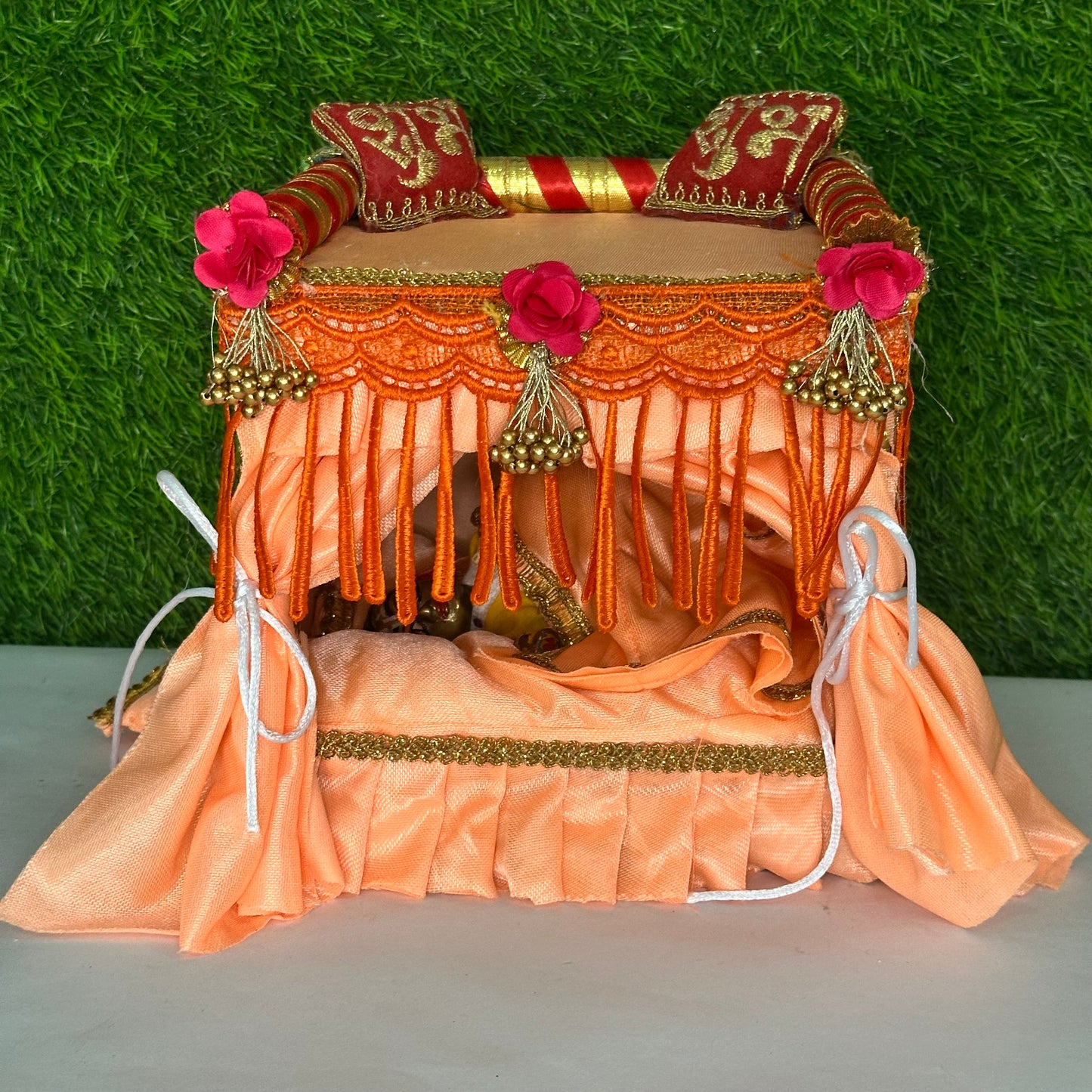 Peach color laddu gopal ji singhasan and bed with complete bedding.