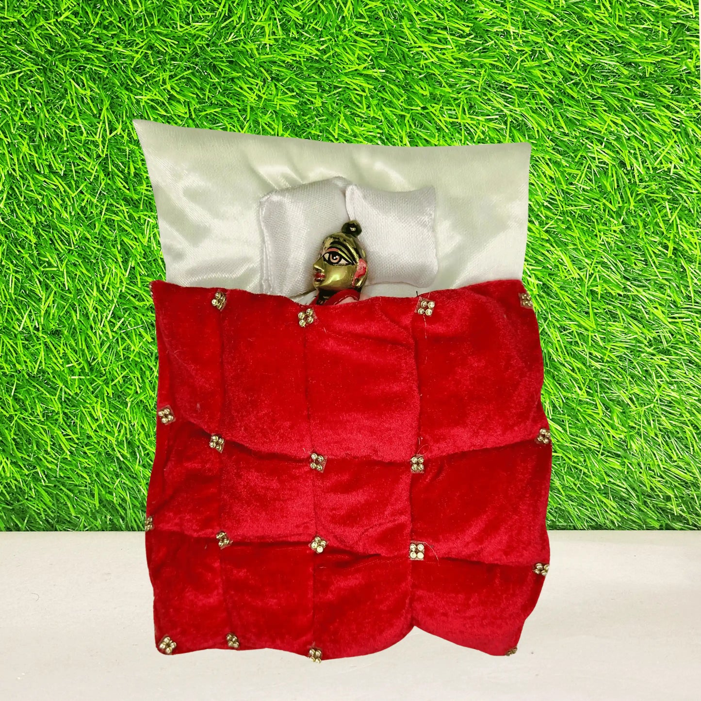 Top view of Laddu Gopal ji sleeping in a Royal Red Velvet Laddu Gopal Bedding Set with Golden Stone Work Blanket & Satin Base