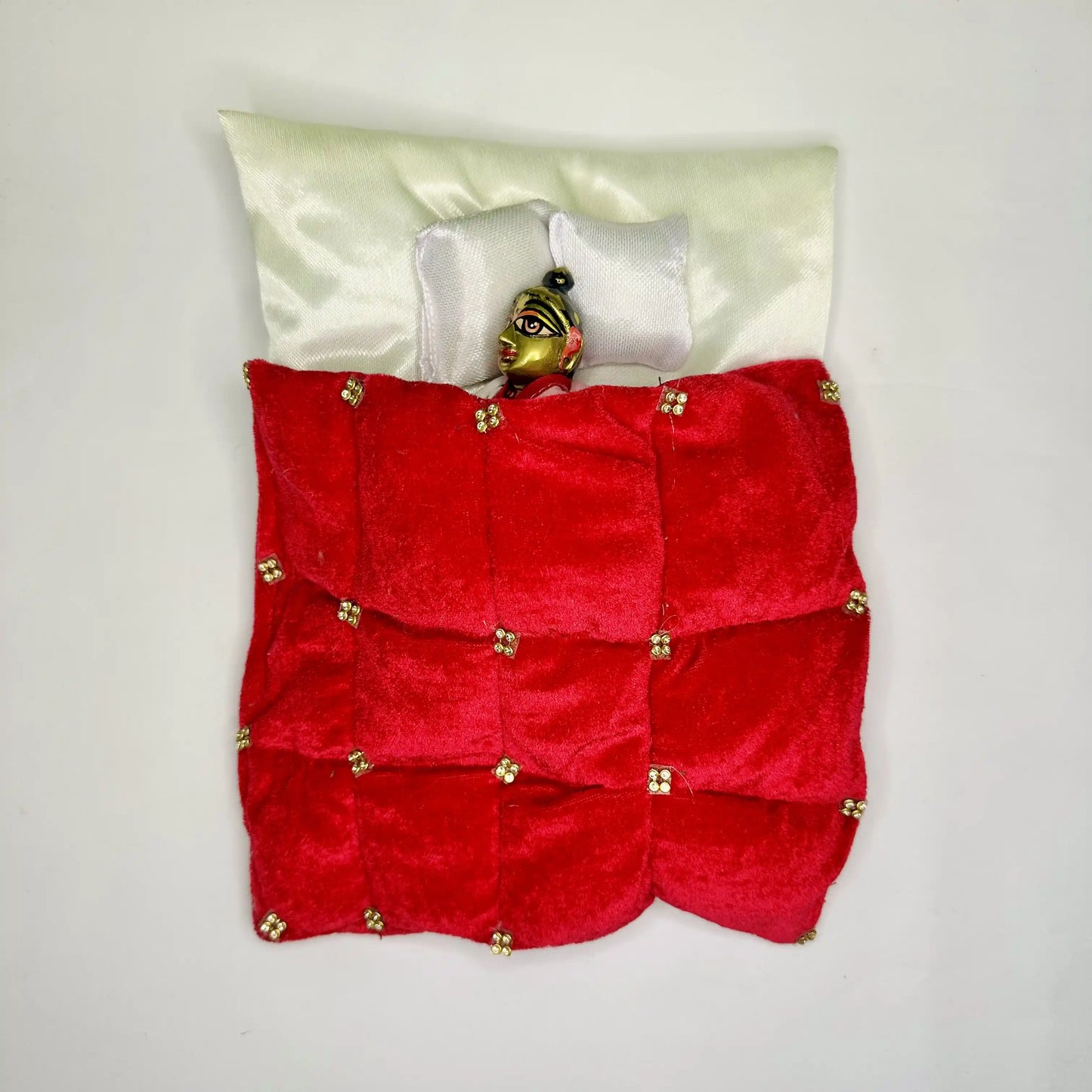 Top view of Laddu Gopal ji sleeping in a Royal Red Velvet Laddu Gopal Bedding Set with Golden Stone Work Blanket & Satin Base