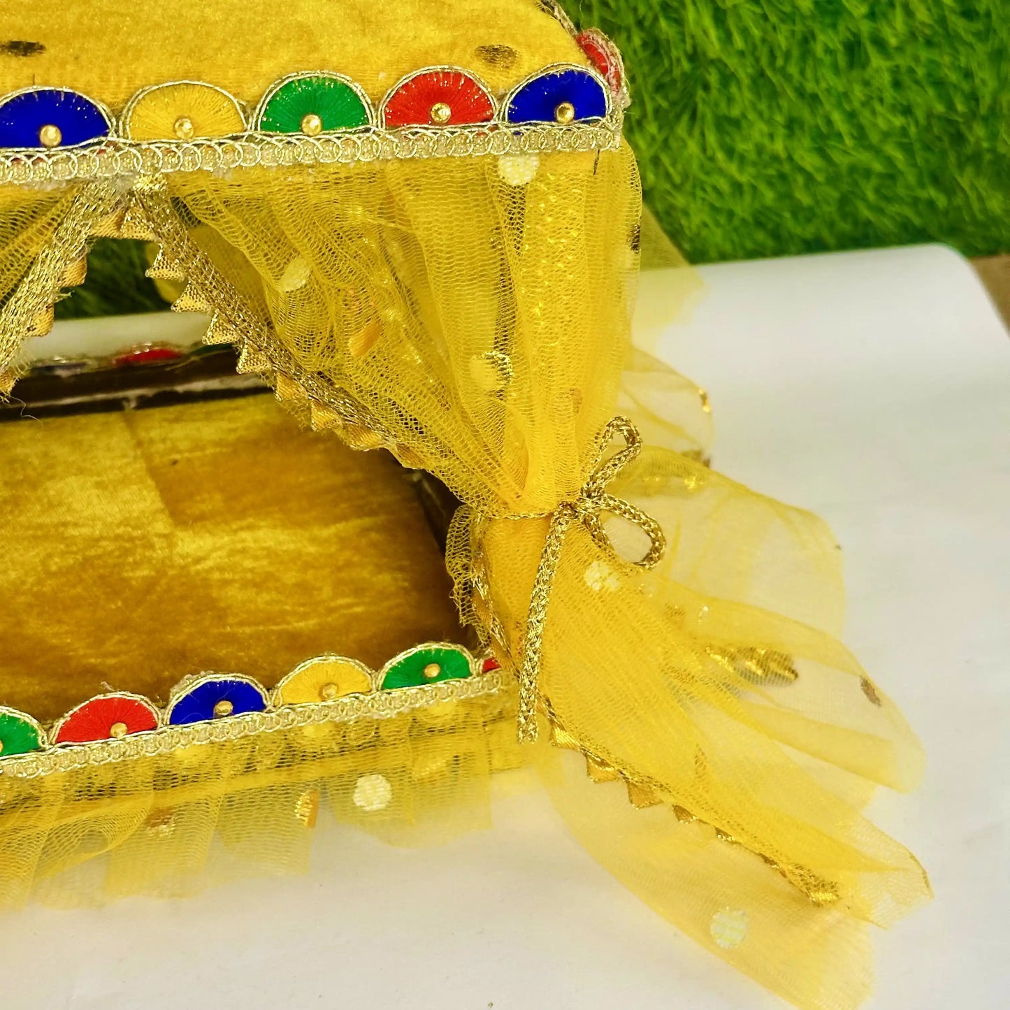 Close view of a Beautiful Yellow Laddu Gopal Singhasan Bed, Decorative Jhula with Designer Border.