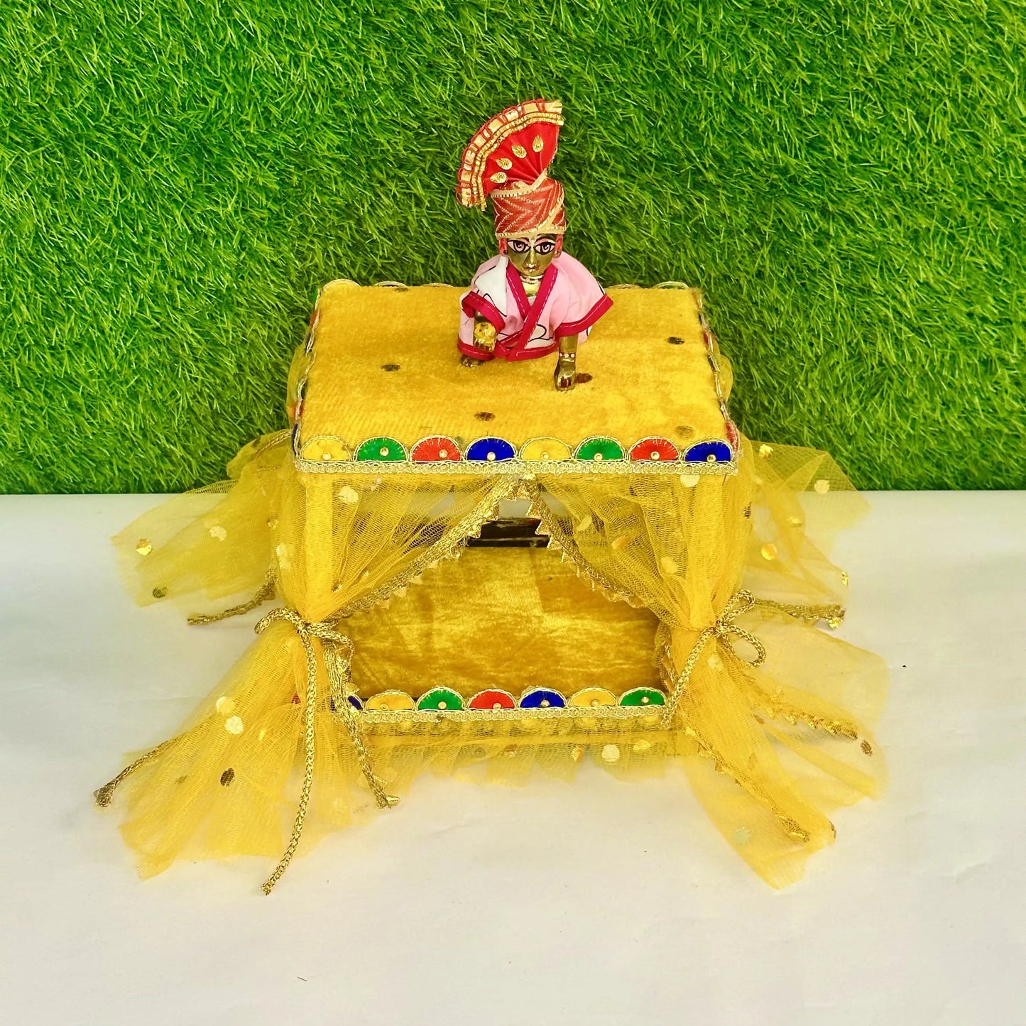 Kanha ji sitting on a Beautiful Yellow Laddu Gopal Singhasan Bed, Decorative Jhula with Designer Border.
