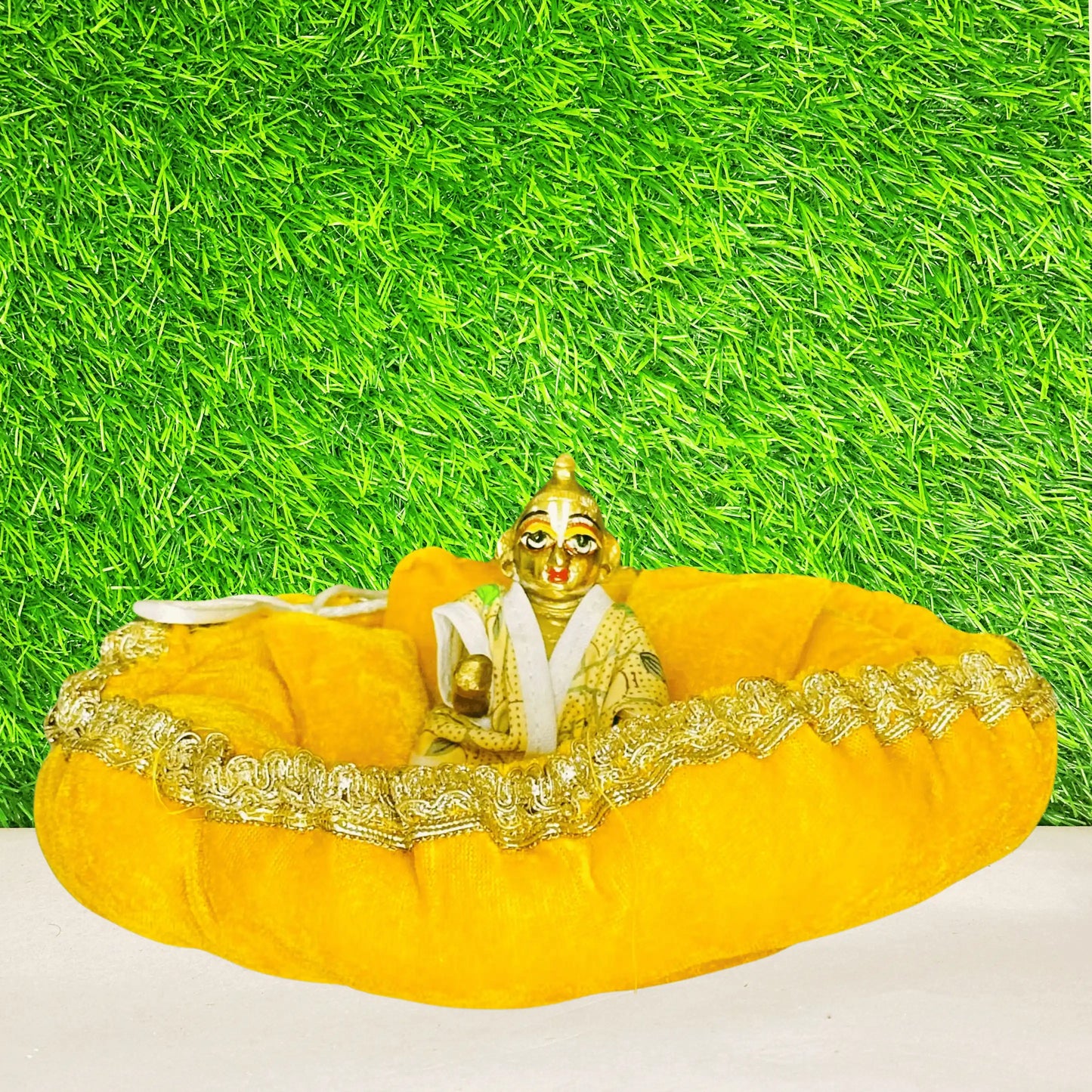 Kanhaji sitting on a Yellow Shaneel Laddu Gopal Bedding Set with Blanket & Pillow.