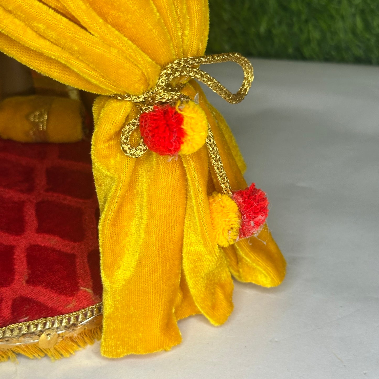 Right close up view of a Royal Yellow Velvet Singhasan for kanha Ji with Pom-Pom Curtains, Pearl Decoration & LED Lights.